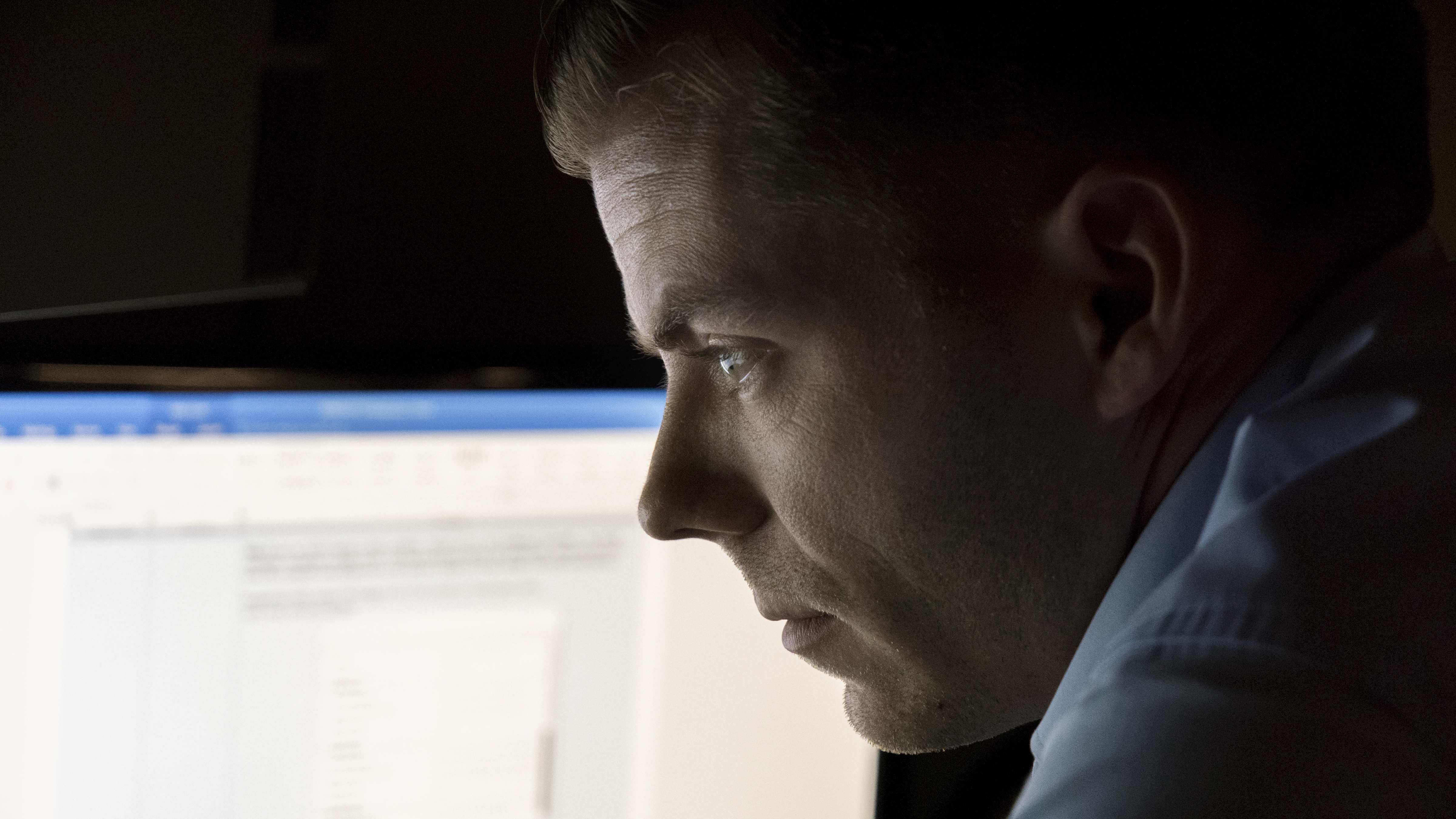 Army CID Special Agent looking at a computer screen 